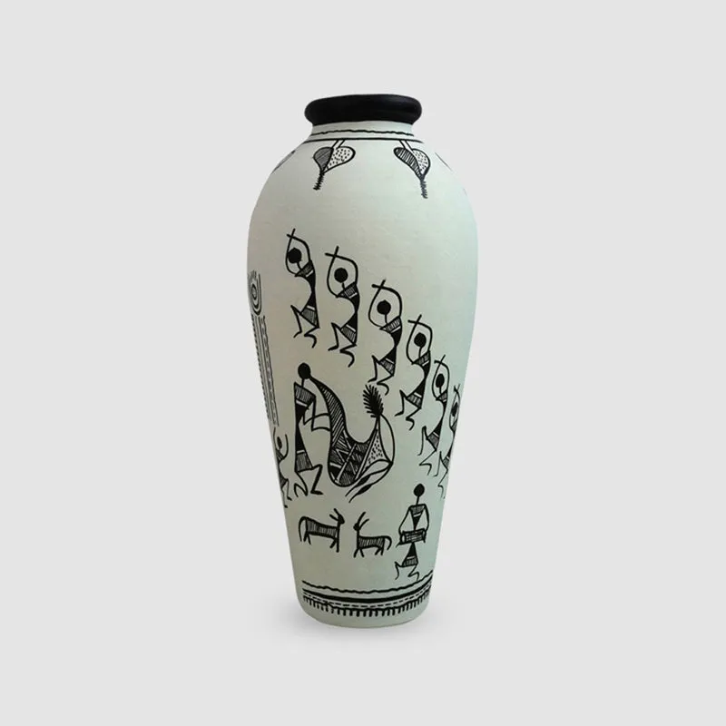 Front view of a white terracotta vase with black Warli motifs