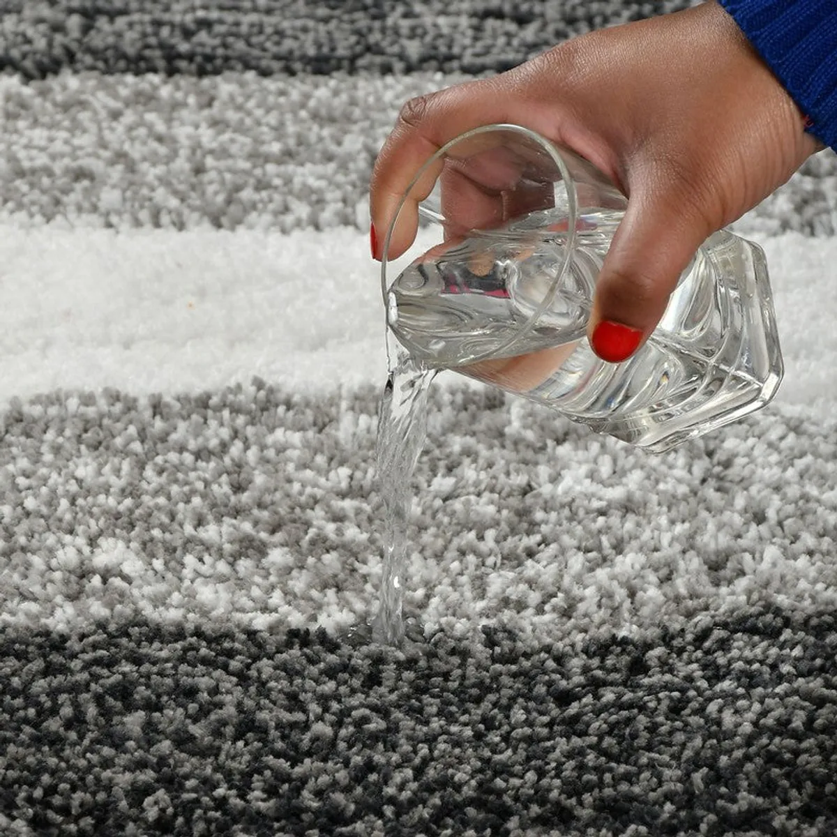 Close view of water being poured onto the striped bath mat