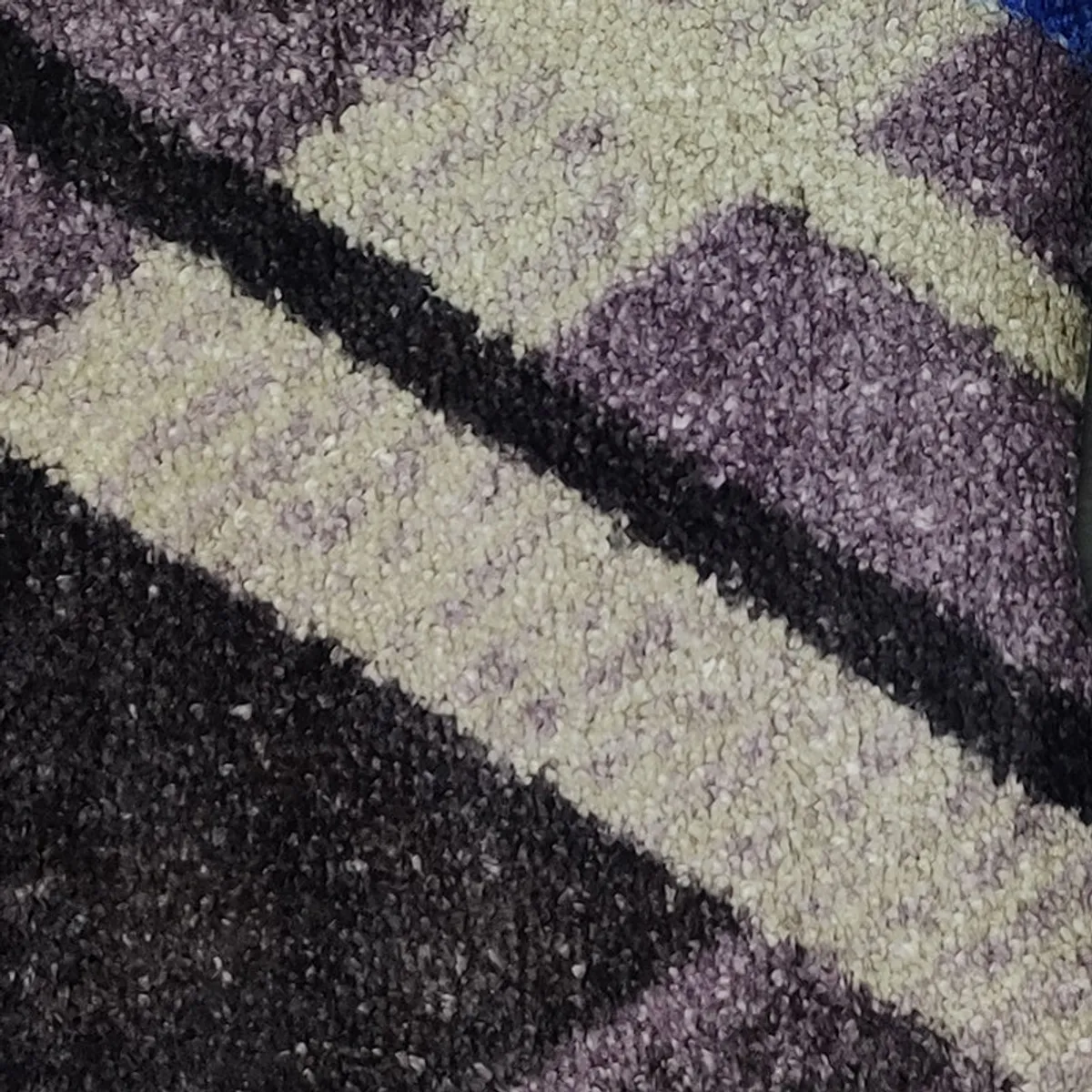 Close-up of the rug's textured geometric pattern in grey, black and cream