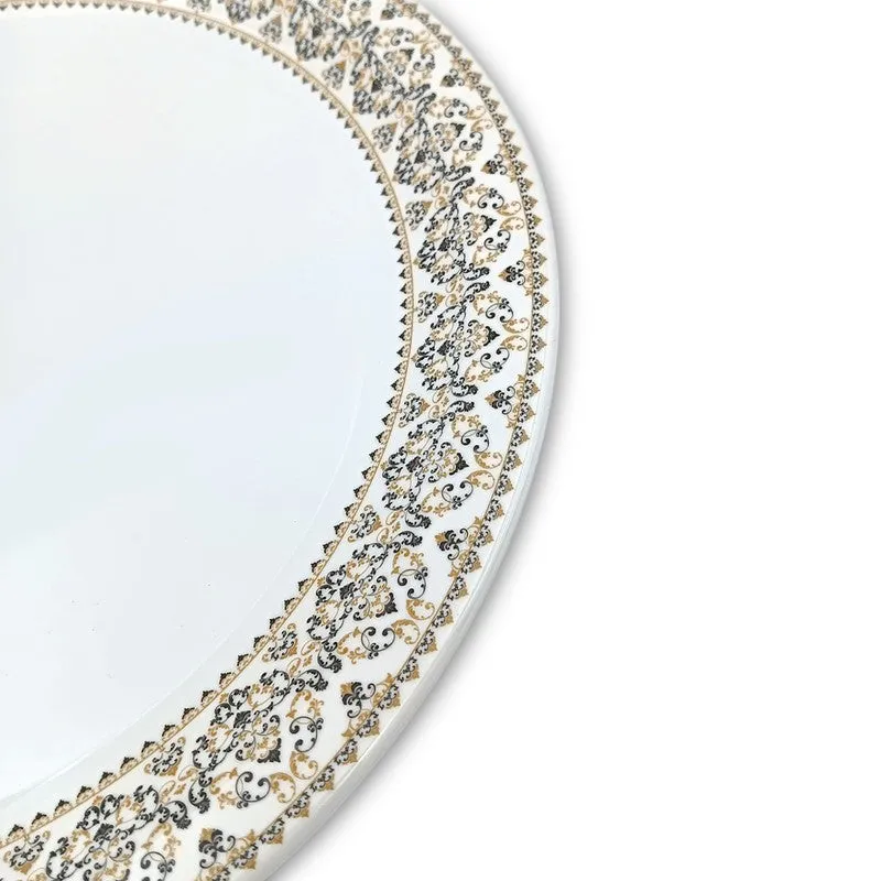 Close-up detail of the ornate gold-toned and dark border around a white plate.