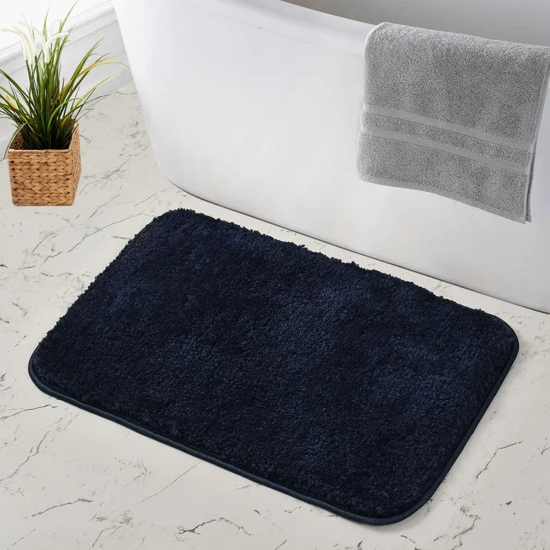 Dark blue rectangular bath mat beside a bathtub
