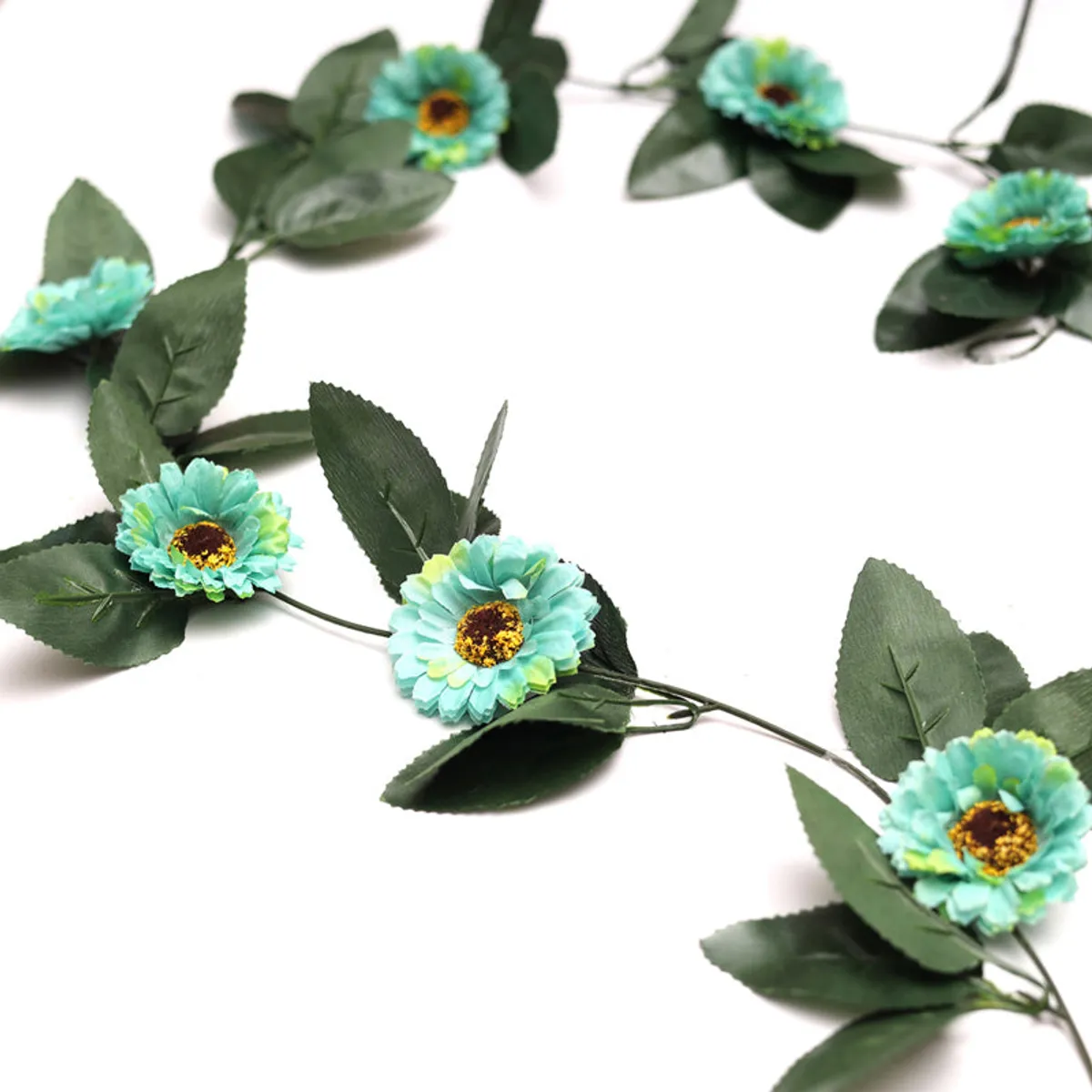 Close-up of blue gerbera flowers and green leaves on an artificial creeper.