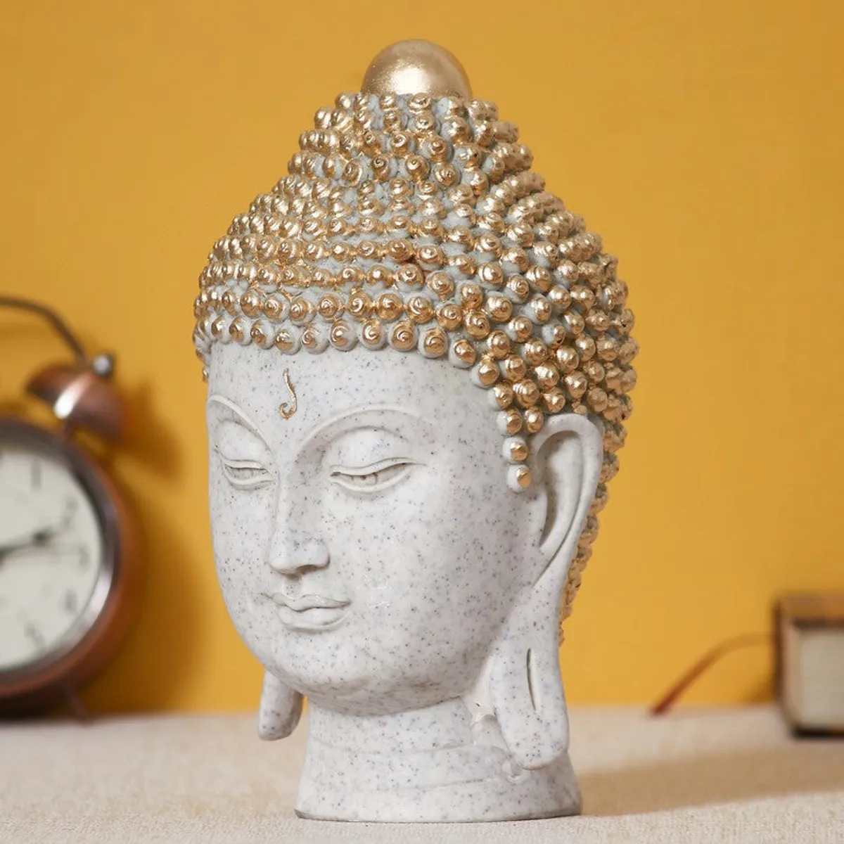 Angled view of white and gold Buddha head idol