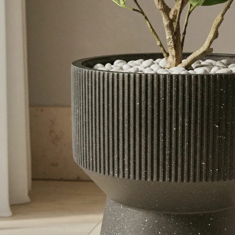 Close-up showing the planter's vertical ribbing and speckled black finish.