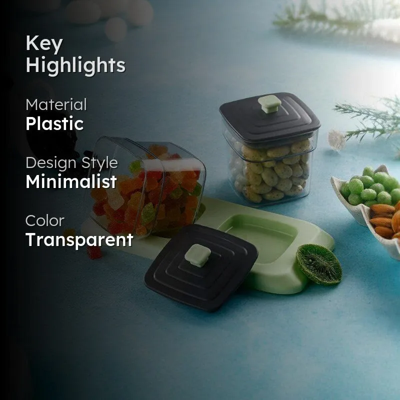 Transparent storage containers with black lids and mint tray in a styled kitchen scene.
