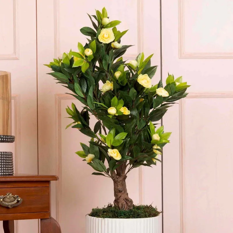 Close view of yellow artificial flowers and green leaves on a flowering plant