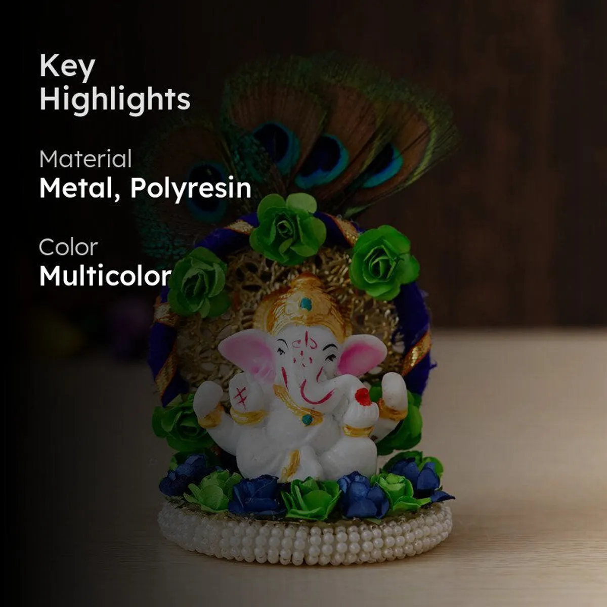 Ganesha idol displayed on a tabletop with peacock feathers and colourful floral accents