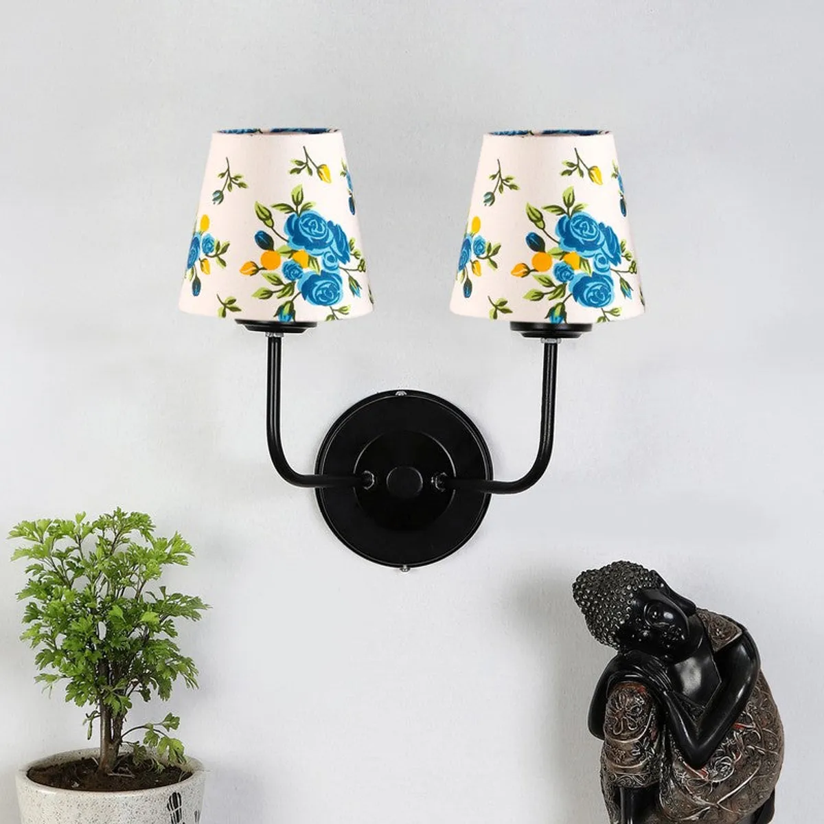 Front view of twin wall lamp with white shades and black iron wall mount