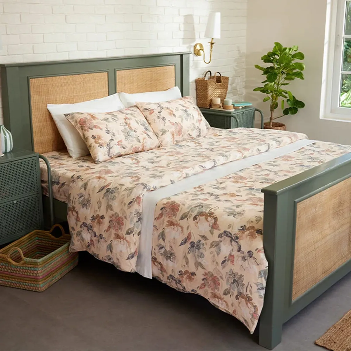 Beige floral bedding styled on a bedroom bed with a green frame