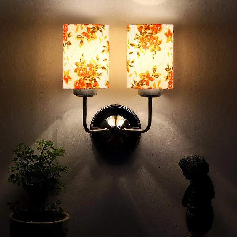 Dual floral wall lamp casting a warm glow on the wall