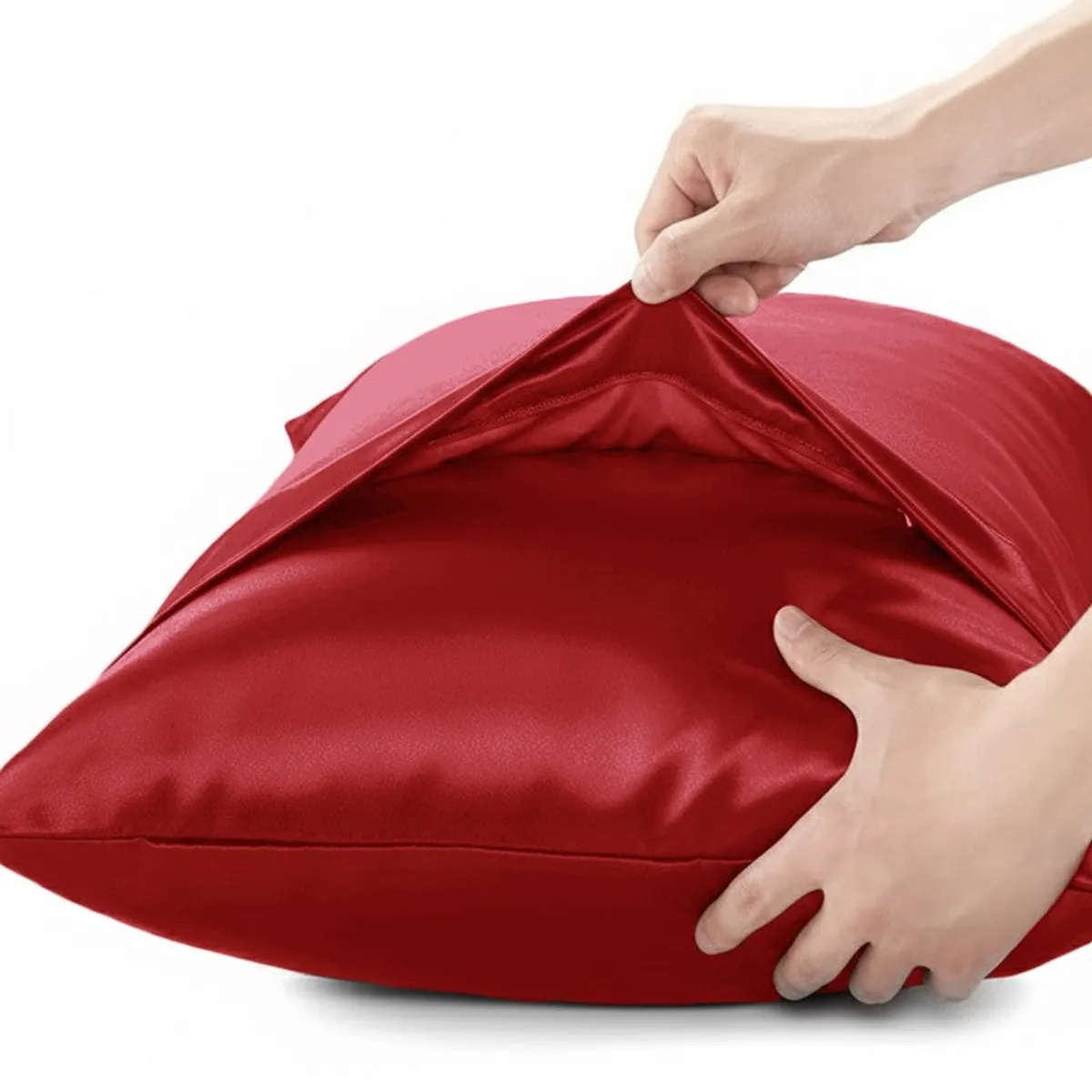 Red satin pillow cover being opened to show its inner space