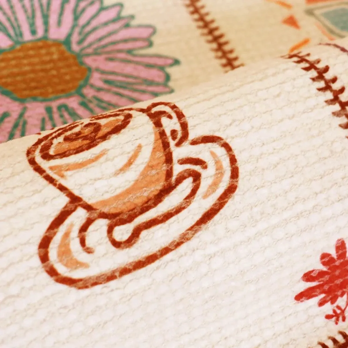 Close-up of carpet surface showing floral and cup motifs on a textured base