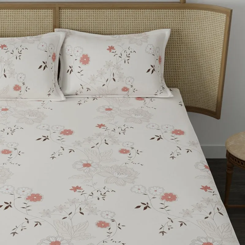 Close view of white bedsheet with peach floral print and matching pillow covers