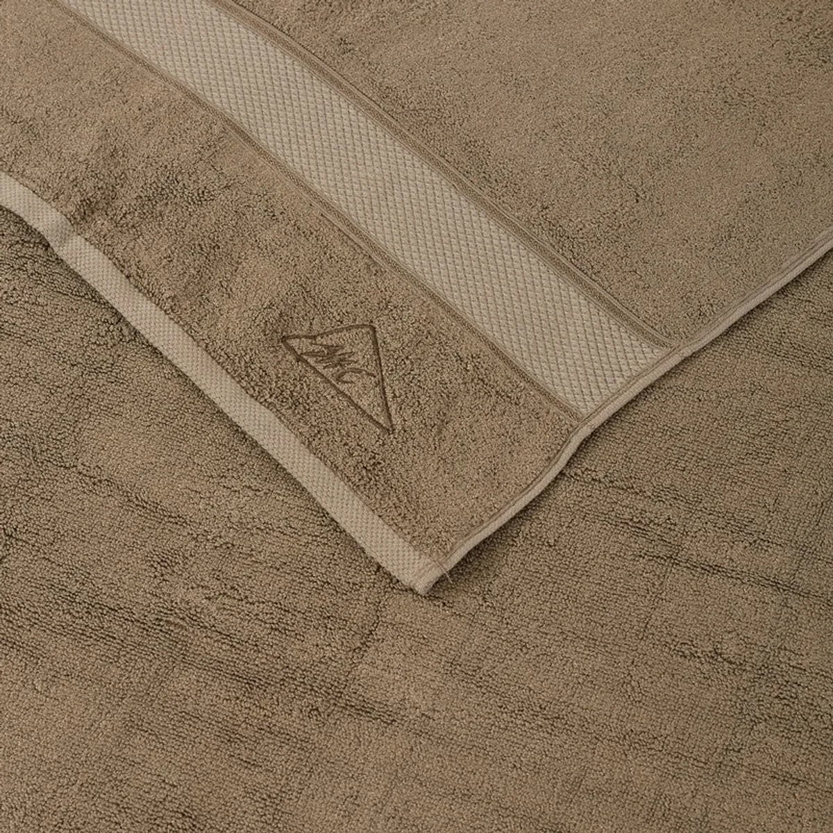 Close-up of the brown towel featuring a subtle border and surface texture.
