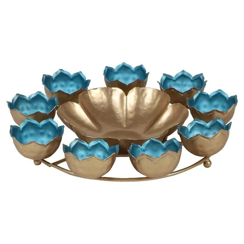 Front view of a gold floral urli with blue flower-shaped holders