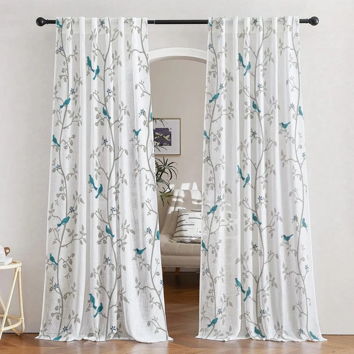 White sheer curtains with blue birds and grey branches framing a doorway