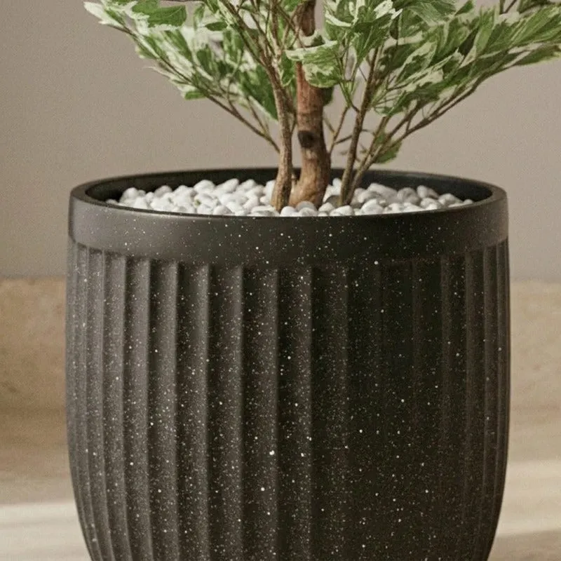 Close-up of the planter's matte black speckled finish and ribbed surface