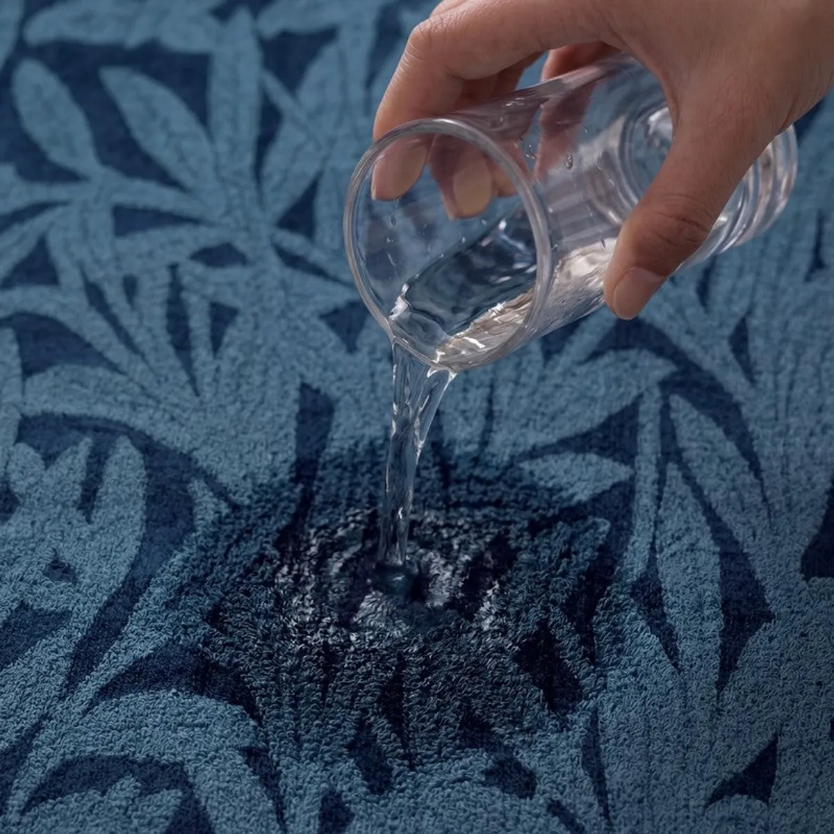 Close-up of water being absorbed by the blue textured towel