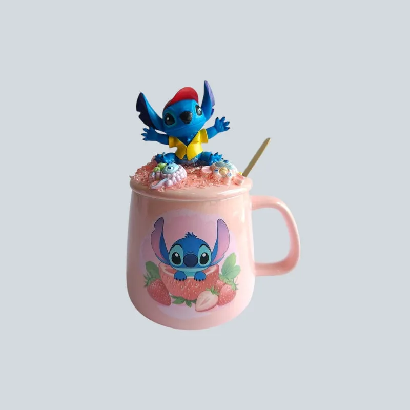 Pink ceramic mug with Stitch print, figurine lid and gold spoon against plain background