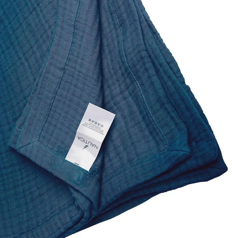 Navy blue bedding fabric folded to show its texture and care label
