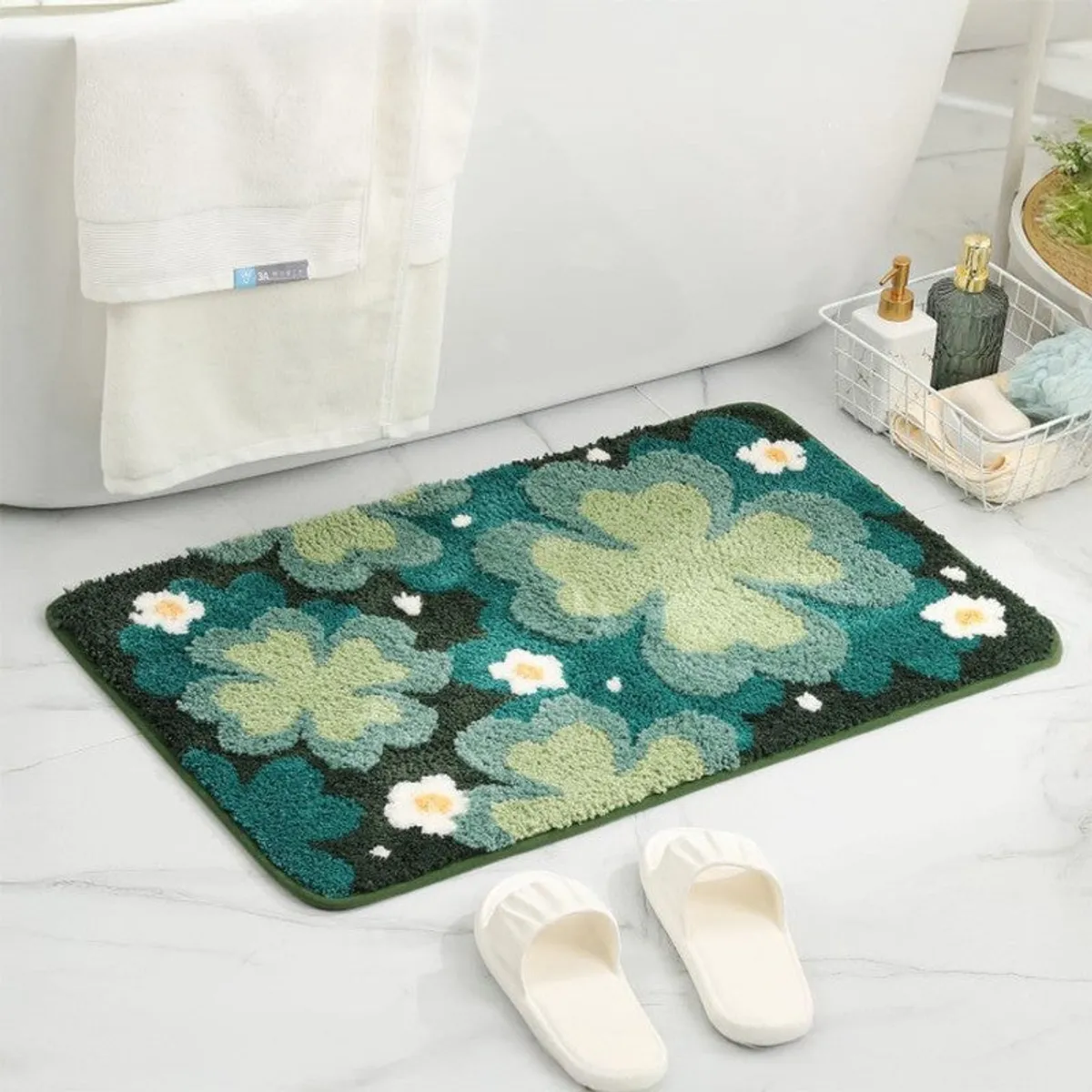 Blue and green floral bath mat shown beside a bathtub on a tiled bathroom floor.