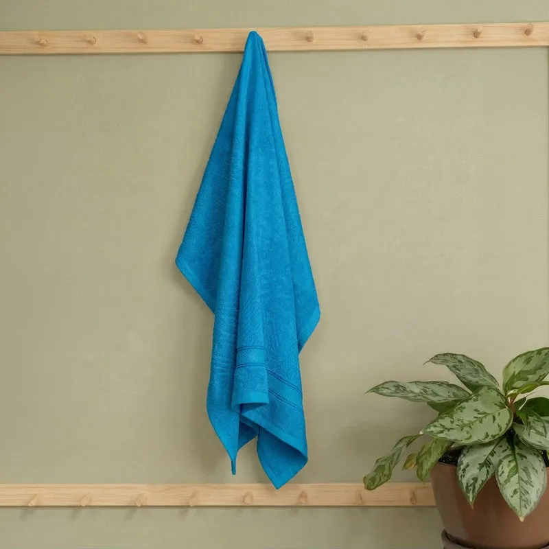 Vivid blue bath towel hanging on a wooden wall rack