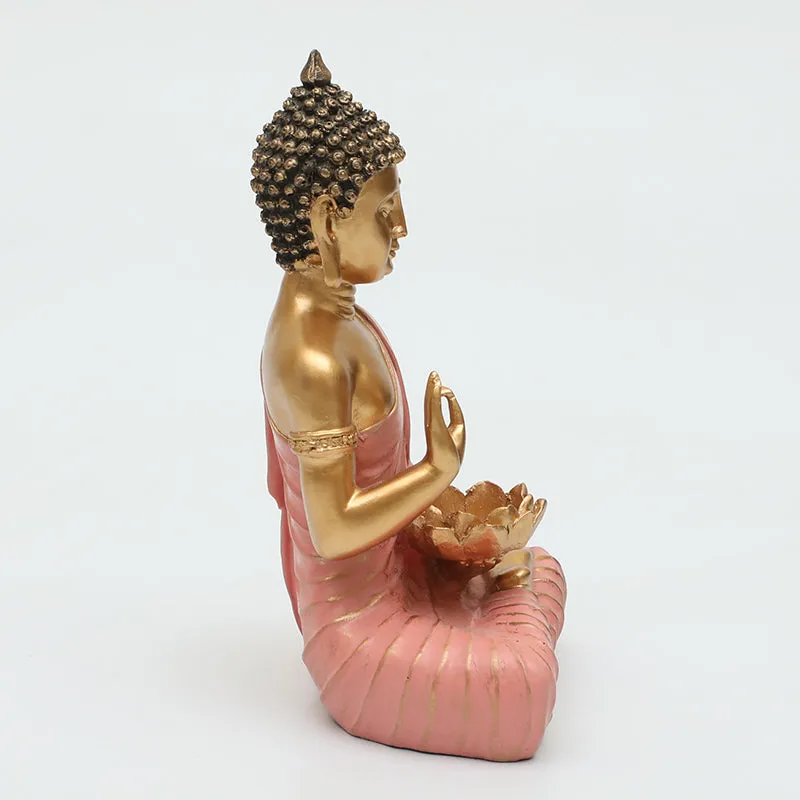 Side view of pink and gold seated Buddha idol