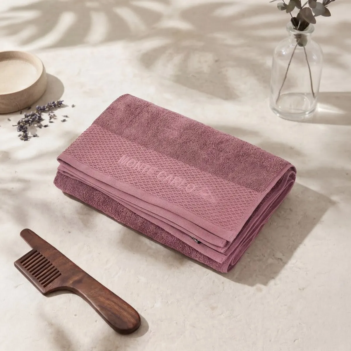 Folded dusty pink bath towel displayed on a tabletop