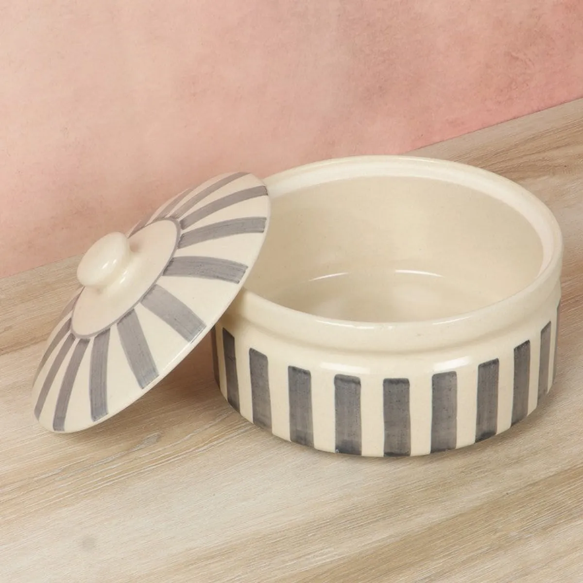 Open grey and white ceramic serving bowl with its striped lid beside it