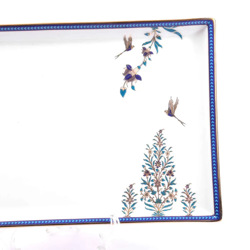 Close-up of blue-bordered platter with floral botanical motifs and bird details