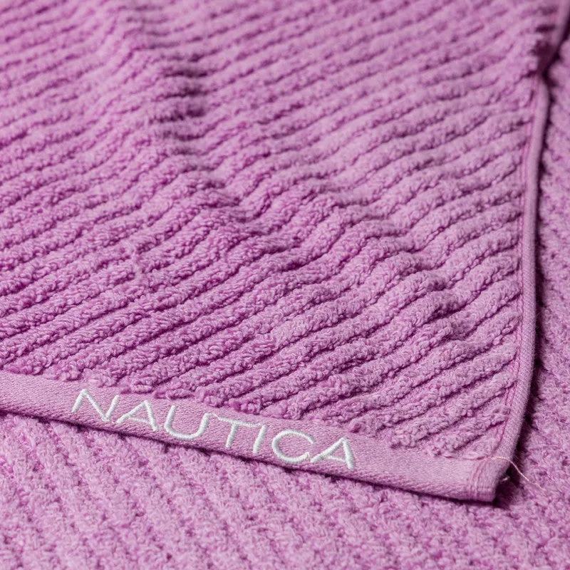 Detailed view of lilac towel with textured surface and woven border