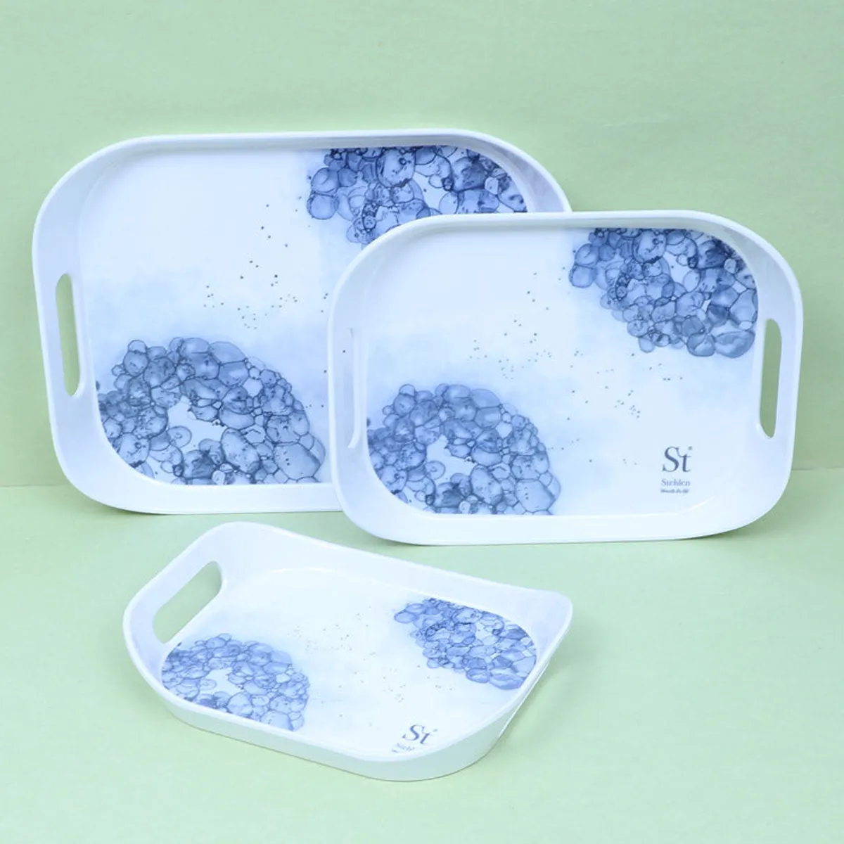 Three rectangular white trays with blue floral detailing shown in overlapping layers.