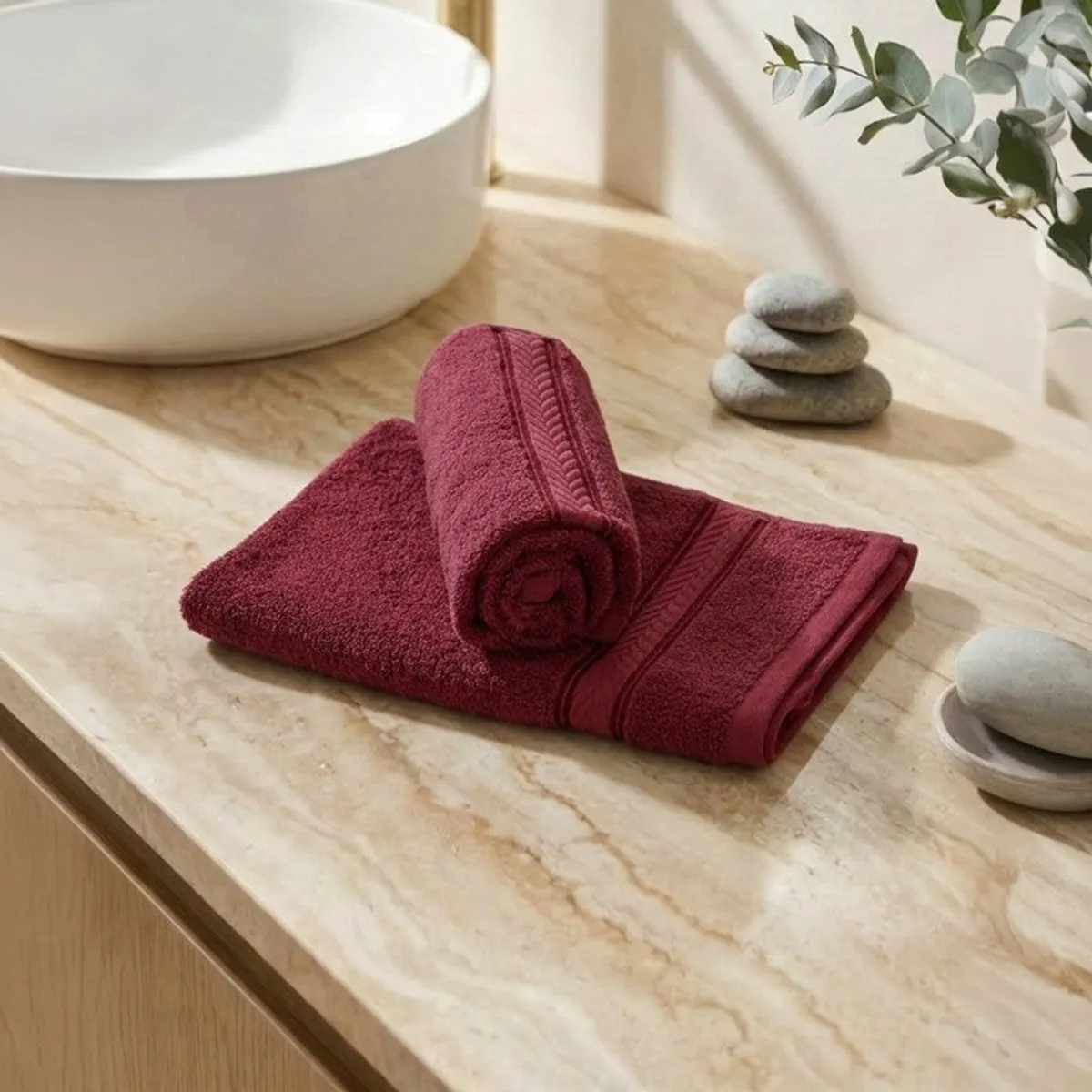 Folded red hand towels displayed beside a white basin