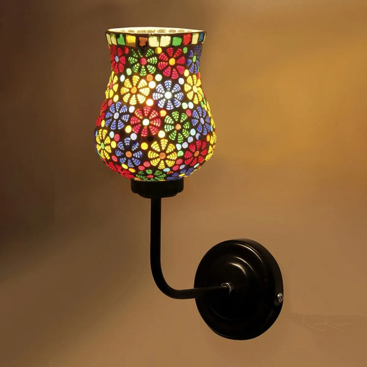 Close-up of lit multicolour mosaic glass wall lamp with black base