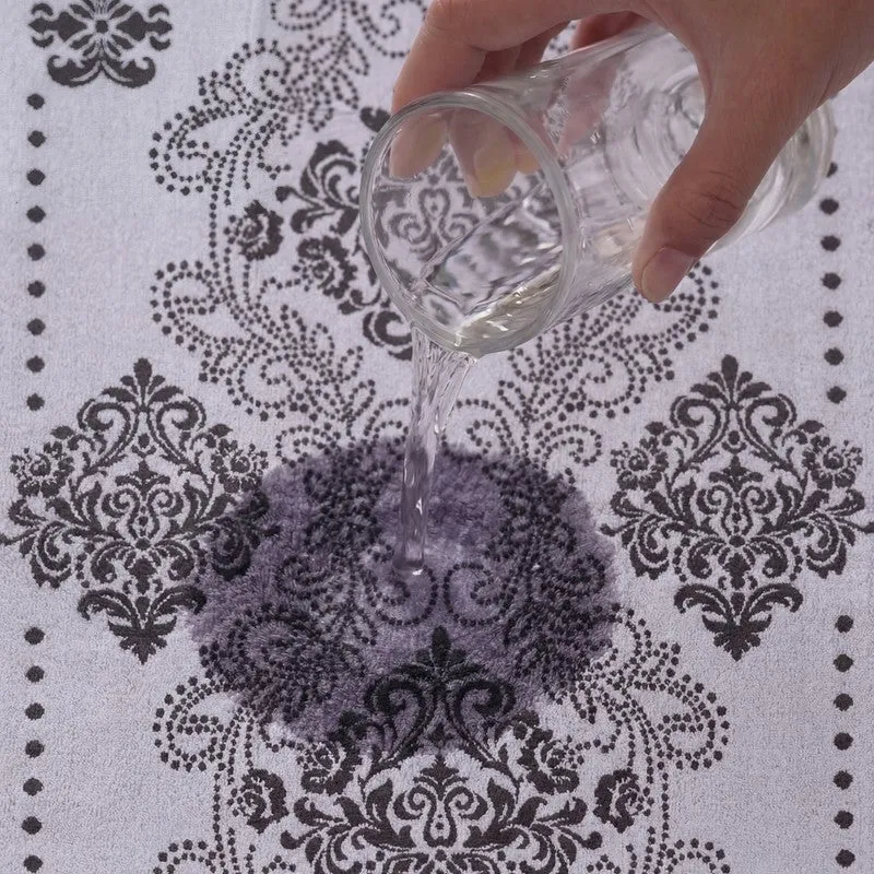 Close-up of water poured onto a grey and white floral towel