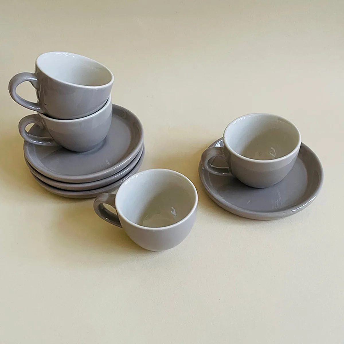 Top view of grey cups and saucers arranged in a compact setting