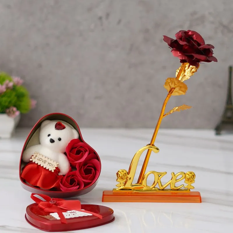 Open red heart gift box beside gold rose with love-shaped base