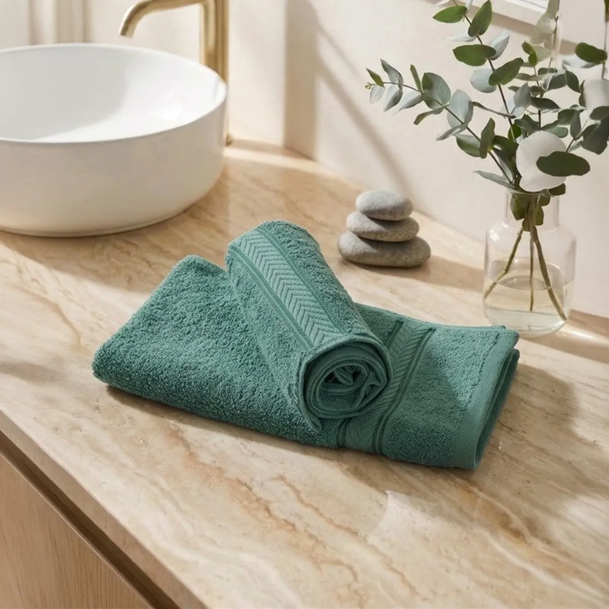 Folded green hand towels on a bathroom counter