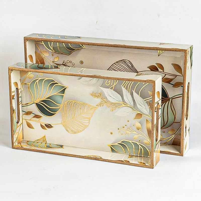 Two white serving trays with gold and green leaf design