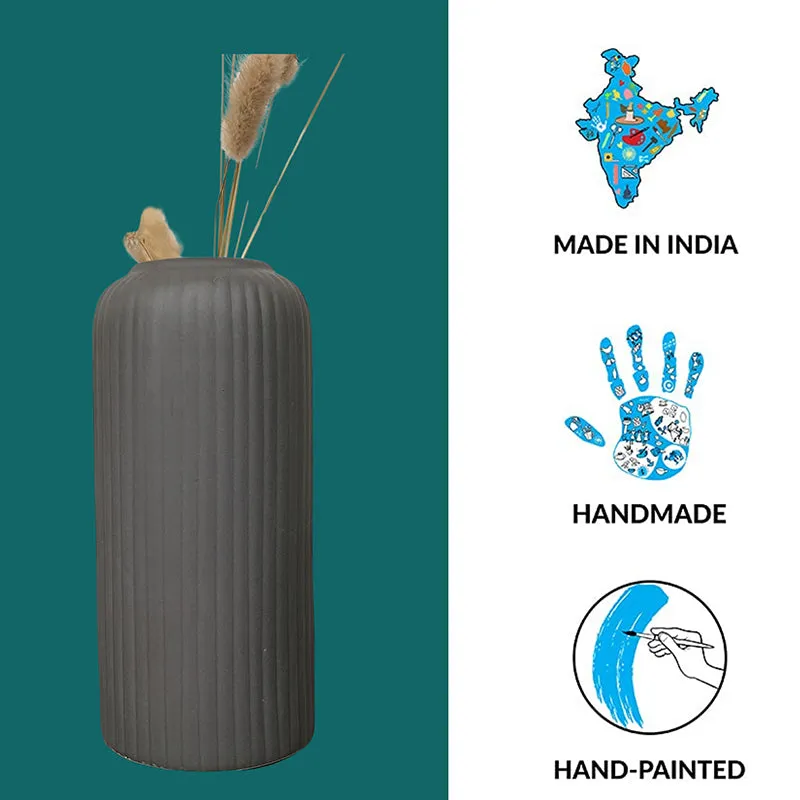 Black ribbed vase with dried stems beside decorative illustrated icons.
