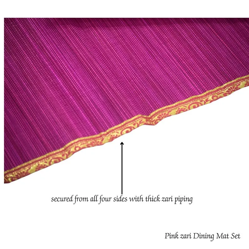 Stacked pink rectangular table mats showing textured surfaces and zari borders
