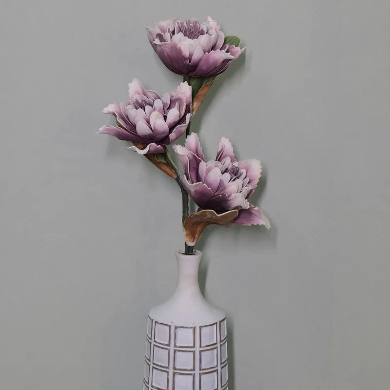 Tall purple artificial dahlia stem displayed in a white patterned vase