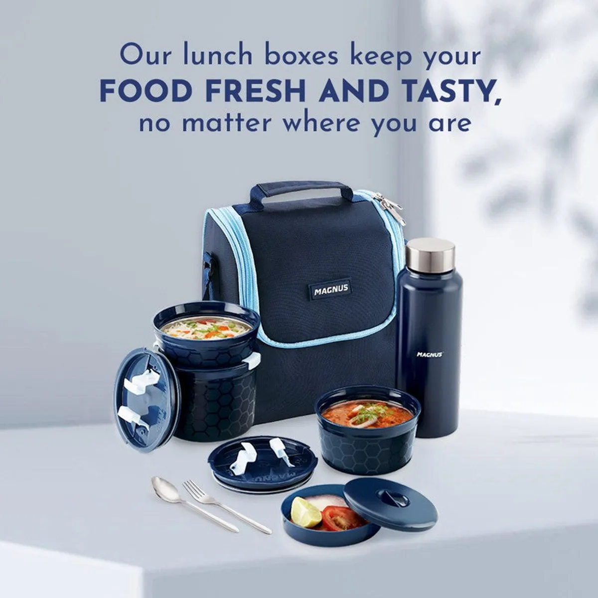 Blue lunch bag and meal containers styled with a bottle against a bright background