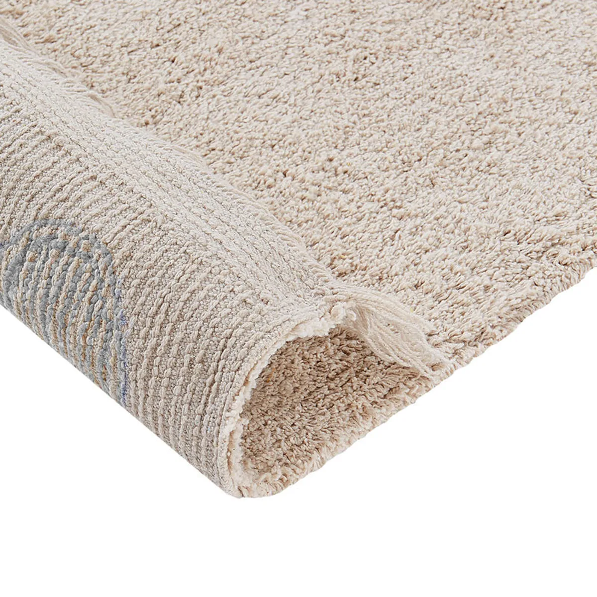 Rolled corner showing the rug's textured cotton pile and grey underside