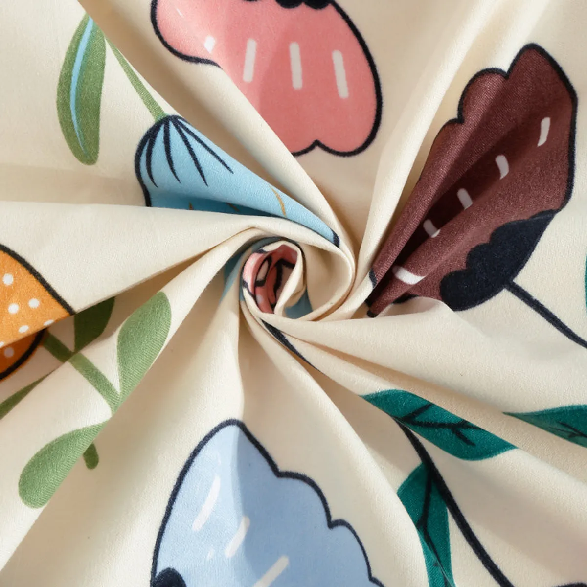 Close-up of cream fabric with pastel floral print twisted to show texture