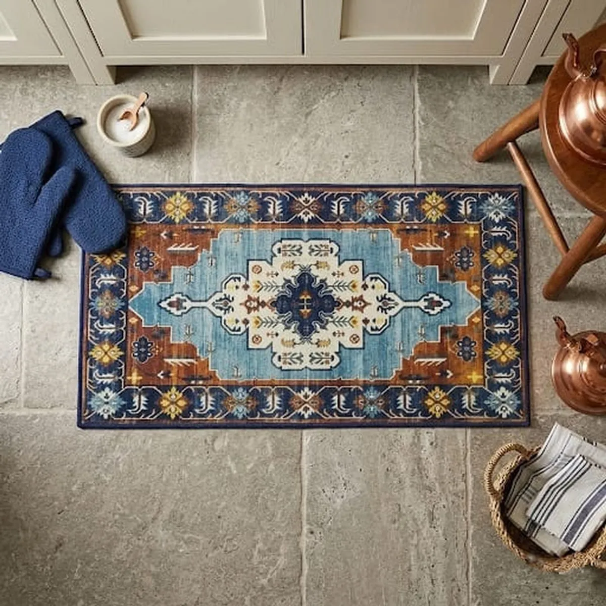Blue and beige ethnic carpet styled on a tiled floor