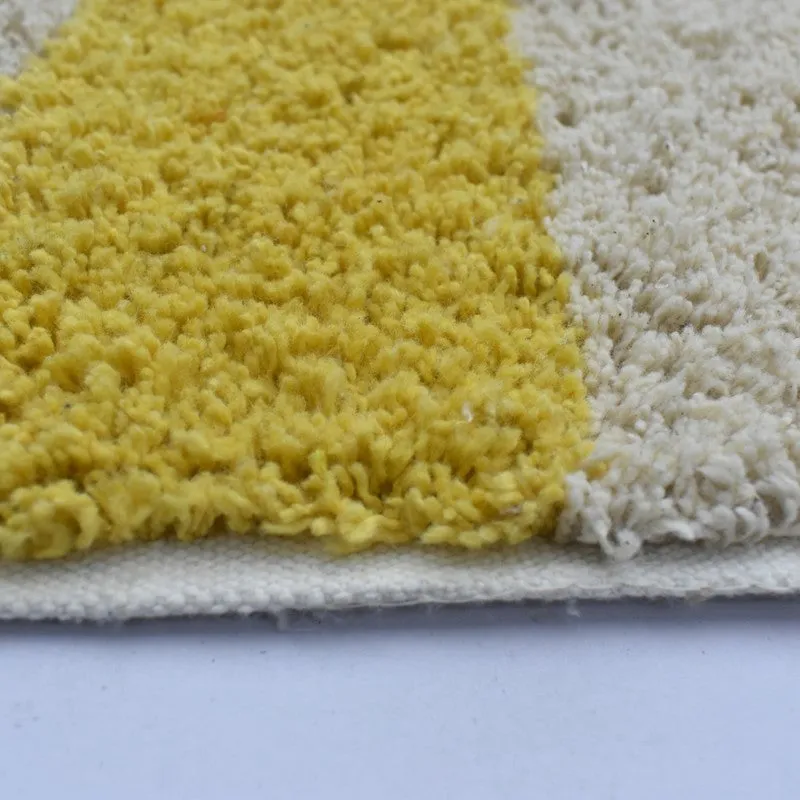 Close-up of the bath mat's yellow and white textured cotton surface