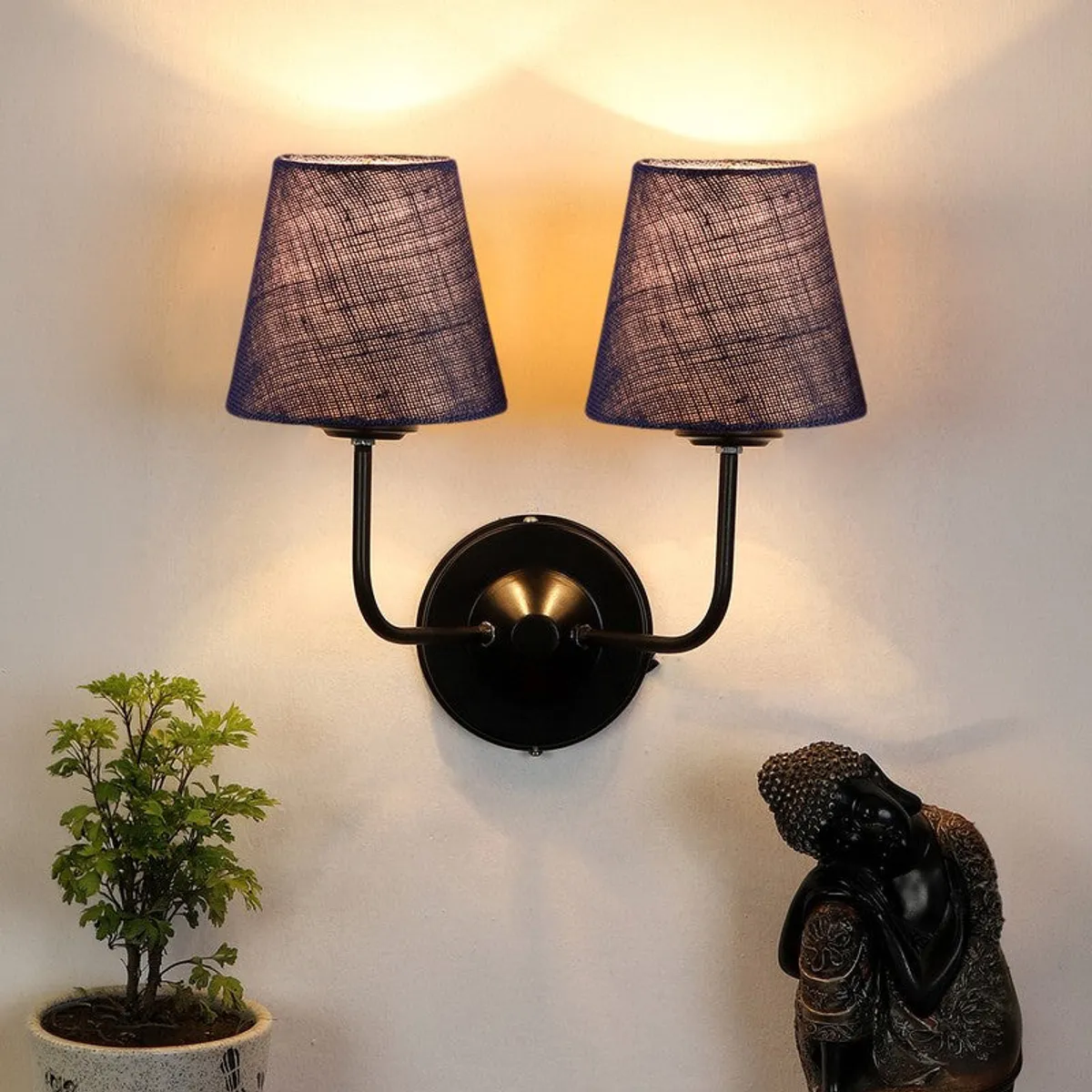 Blue double-shade wall lamp with black iron arms and warm light