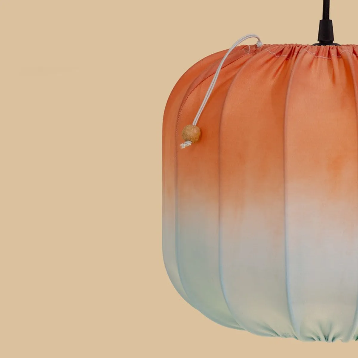 Close-up of the orange satin shade, ribbed detailing and hanging cord