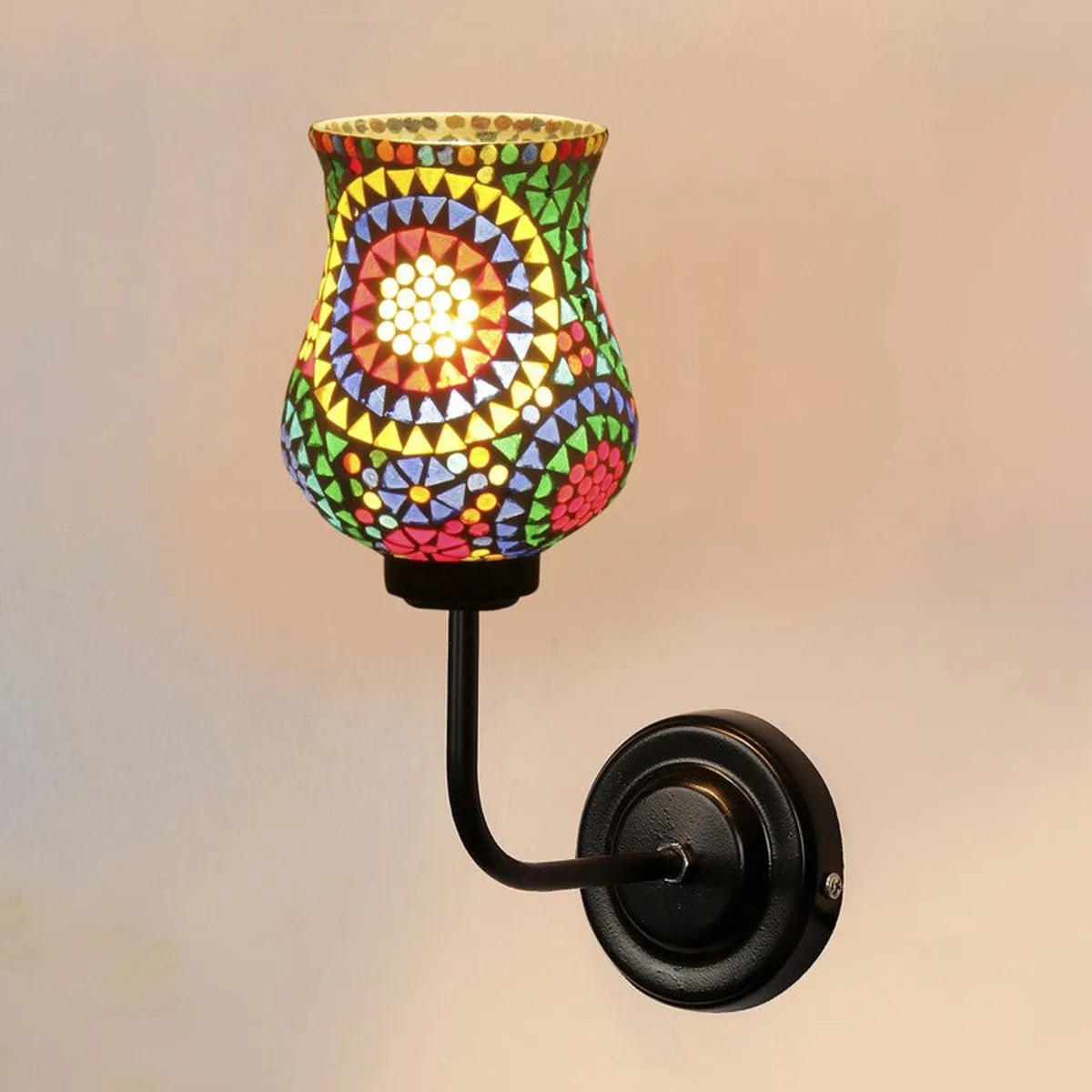 Close-up of colourful mosaic glass shade on black iron wall lamp